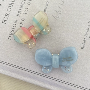 Close-up of acetic acid butterfly hair clips with marble texture and rhinestones