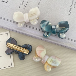 Detail of a sparkling acetate butterfly hair clip with rhinestones and golden metal clip