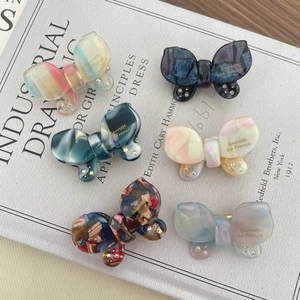 Detail of elegant acetate butterfly hair clips with sparkling rhinestones and marble patterns