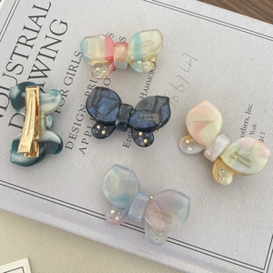 Set of iridescent acetate butterfly hair clips with marble texture and rhinestones