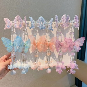 Dettaglio di fermagli per capelli a farfalla ricamati con lunghe nappe in colori pastello