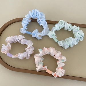Set of four sweet pastel scrunchies with colorful polka dots in a decorative tray
