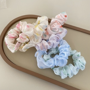 Polka dot ruffled scrunchies set in macaron colors on a leather tray for hair styling