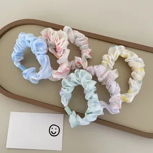 Close-up of pastel polka dot organza hair scrunchies set in a brown leather tray