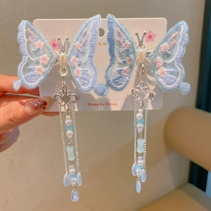 Dettaglio di fermagli per capelli a farfalla in tulle con ricami floreali e lunghe nappe