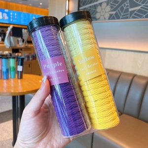 Close-up of vibrant wave-patterned hair ties in clear cylinders for children