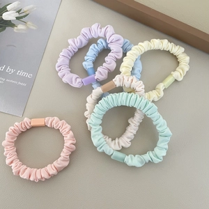 Set of pastel fabric scrunchies with matte square buckles on a beige texture