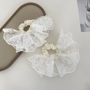 Detail of cream lace scrunchie set with delicate floral embroidery and sheer texture