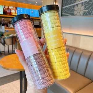 Close-up of children's wavy hair ties in a transparent portable tube with black lid