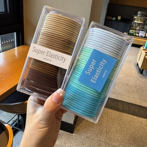 Close-up of candy color elastic hair bands in transparent boxes with OOTD labels