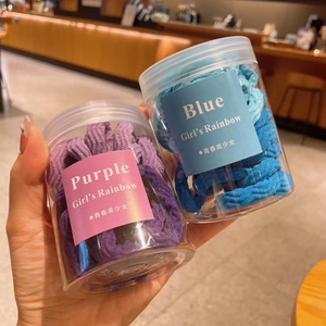 Détail d'élastiques à cheveux bleus et violets en bocaux avec tissu texturé doux