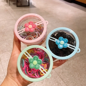 Close-up of colorful elastic hair bands in transparent storage boxes with floral lids