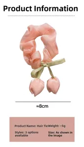 Gros plan sur un chouchou tulipe rose avec nœud en satin vert et pendentifs fleurs