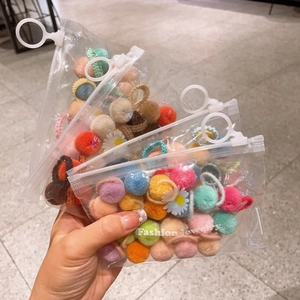 Colorful plush ball hair ties set for girls in a clear zip bag featuring cute daisy designs