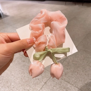 Chouchou en satin rose avec nœud vert et breloques tulipes sur carte blanche