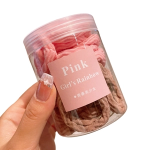 Lot d'élastiques à cheveux roses et marrons présentés dans un bocal transparent