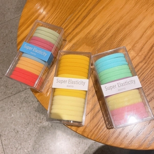 Close-up of high-elasticity colorful seamless hair ties in portable transparent boxes