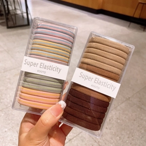 Detailed view of high elasticity hair ties in assorted colors and patterns within two boxes
