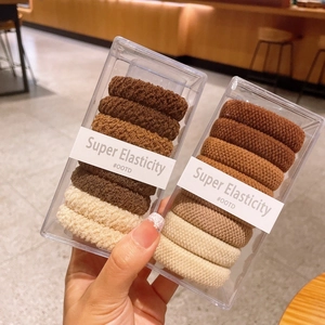 Gros plan d'élastiques à cheveux côtelés aux tons terre avec emballage transparent