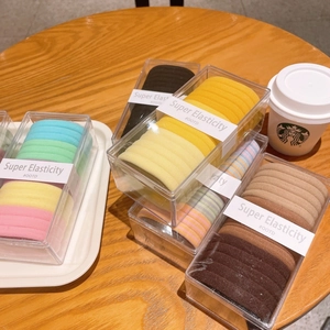 Macro shot of colorful high elasticity hair ties in a clear rectangular plastic box