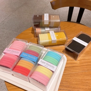 Detailed macro view of colorful seamless towel hair bands in elegant plastic gift box