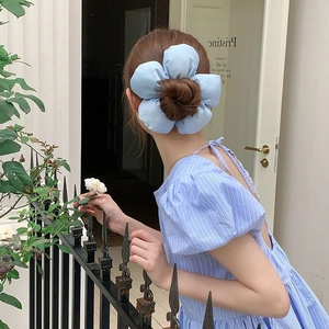 Oversized light blue satin flower hair tie shown on a low ponytail for a stylish look