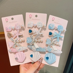 Détail d'un lot de barrettes thème océan avec coquillages, étoiles de mer et perles