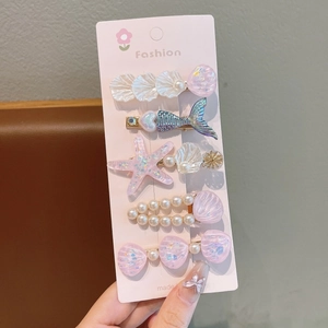 Détail de 5 pinces à cheveux thème océan avec coquillages, queues de sirène et perles