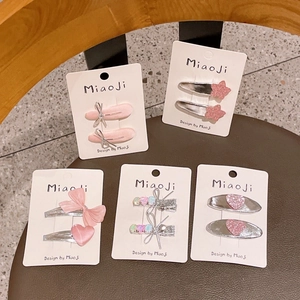 Dettaglio di fermagli per capelli argento e rosa con cuori glitter su espositori