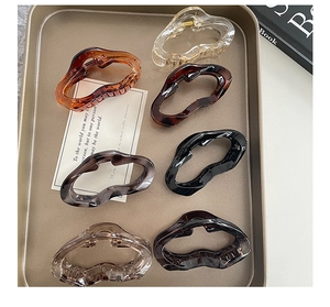 Détail de six pinces à cheveux de couleurs variées dans un plateau doré élégant