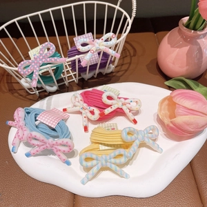 Close-up of colorful resin bow hair ties set with plaid and polka dot patterns