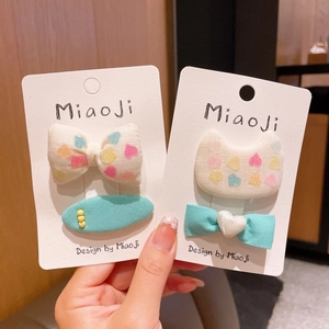 Detail showing two sets of fabric bows and clips with heart patterns and cat shapes