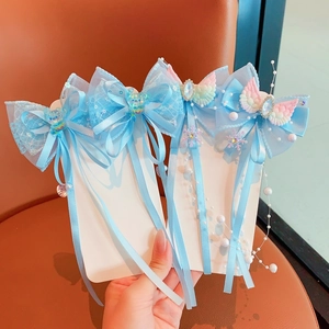 Detail of light blue lace butterfly hair clips with pearls and long ribbon tassels
