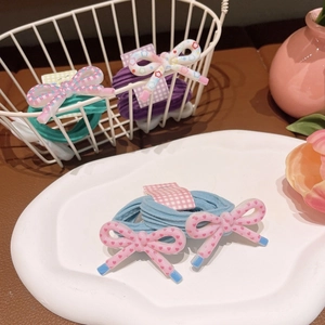 Close-up of pastel resin bow hair ties with star patterns on a display tray