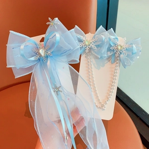 Detailed view of blue tulle butterfly hair clips with snow-shaped crystals and pearl tassels