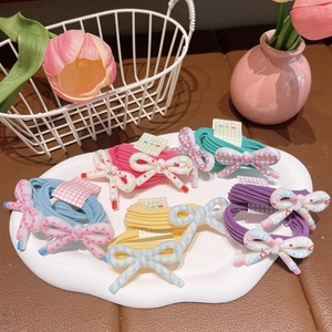 Colorful kids hair ties with polka dots and plaid resin bow knots in a decorative tray