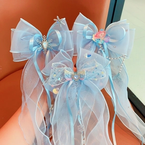 Close-up of blue butterfly hair clips with organza ribbons, pearls and heart charms