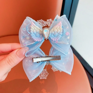 Detail of light blue mesh butterfly clip with angel wings and crystal snowflake pendant