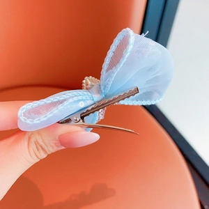 Close-up of light blue mesh butterfly hair clip with crystal and metal duckbill grip