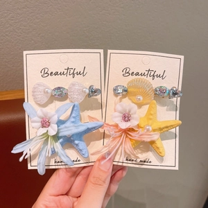 Detail of handmade ocean theme starfish and flower hair clips with pearls and gems