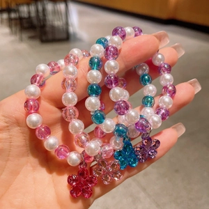 Detail showing elastic beaded bracelets with colorful flower charms for little girls