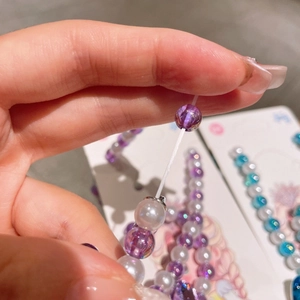 Detail of girls' beaded jewelry showing the elastic stretch and purple crystal beads