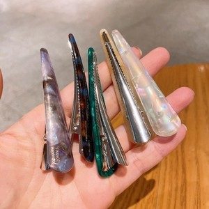 Close-up of five handmade acetate hair clips with marble patterns and France engraving