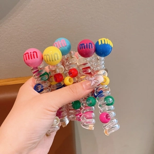 Close-up of colorful spiral hair ties with large min letter beads for girl hairstyles