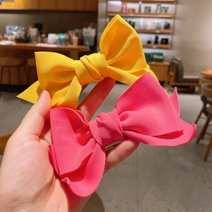 Set of large yellow and pink fabric bow hair clips with metal duckbill clips for girls