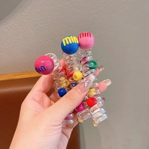 Close-up of spiral telephone wire hair ties with colorful beads and mini ball accents