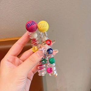 Detail showing pink and yellow spiral phone line hair ties with large colorful beads