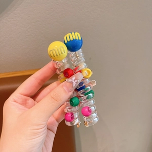 Detail of spiral telephone wire hair tie with colorful beads and letter print decoration