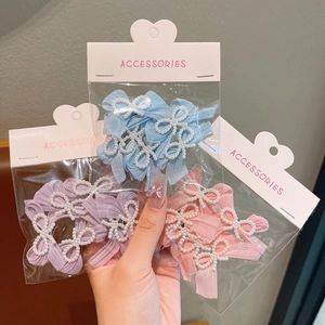 Detail of girl's pearl ribbon bow hair clips in blue, purple, and pink packaging