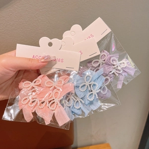 Detailed view of handmade bow hair clips with pearls and ribbons in soft pastel colors